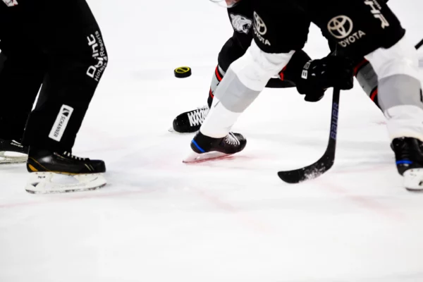 Markus Spiske photo credit. close up of hockey players on ice battling over a puck.